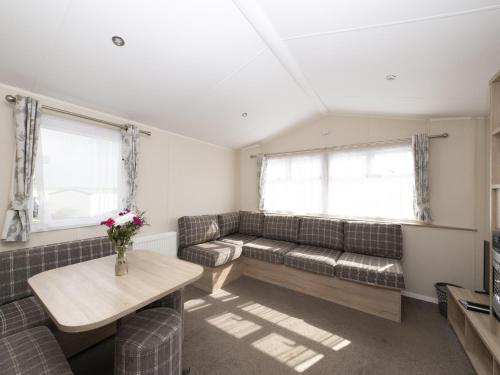 a living room with a couch and a table at Suncrest Caravan by Belvilla in Looe