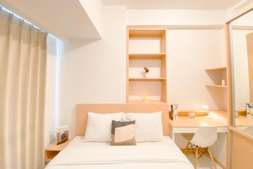 a small bedroom with a bed and a desk at Good and Cozy Stay 2BR Tokyo Riverside PIK 2 Apartment By Travelio in Tangerang