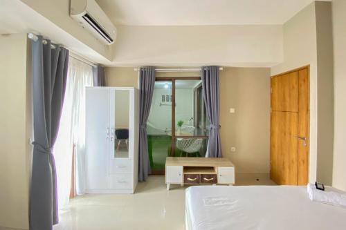Katil atau katil-katil dalam bilik di Homey and Nice 1BR at Gateway Park LRT City Bekasi Apartment By Travelio