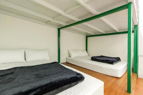 two beds in a room with green and white at Rich House B&B in Kenting