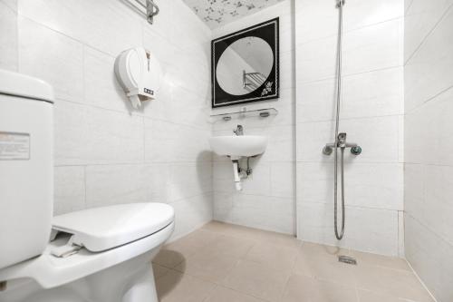 a bathroom with a toilet and a sink and a shower at Rich House B&B in Kenting