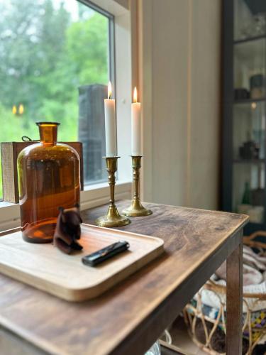 a table with two candles and a remote control on it at Idyllic Holiday Home In Ebeltofts Nature in Femmøller