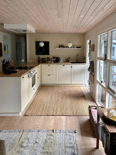a large kitchen with white cabinets and a wooden floor at Idyllic Holiday Home In Ebeltofts Nature in Femmøller