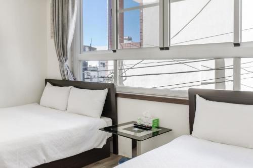 a hotel room with two beds and a window at Rich House B&B in Kenting
