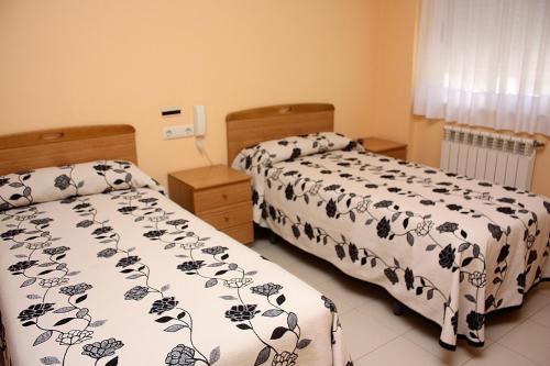dos camas sentadas una al lado de la otra en un dormitorio en Residencia Porta Nova, en Ferrol