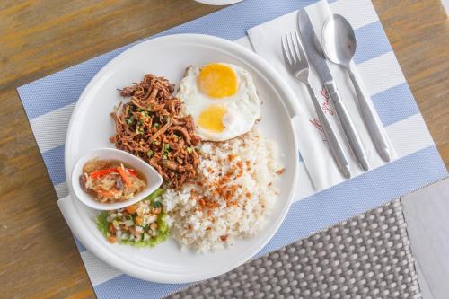 a plate of food with rice and an egg on it at TRYP by Wyndham Mall of Asia Manila in Manila