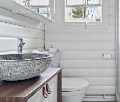 a bathroom with a sink and a toilet at Charming Log Cabin With Modern Luxury in Jordet