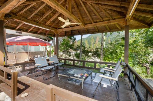 an outdoor deck with chairs and an umbrella at Gapyeong GlamDog Pet Pension in Gapyeong