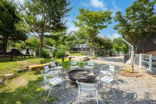 a group of chairs around a fire pit at Gapyeong GlamDog Pet Pension in Gapyeong