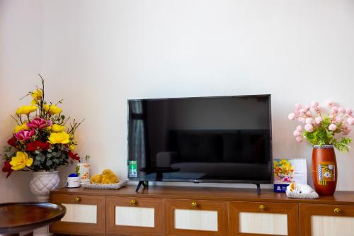 a flat screen tv sitting on top of a dresser at Sun'House- Family 2BR Apt View Sea & Sunset Town Phu Quoc in Phu Quoc