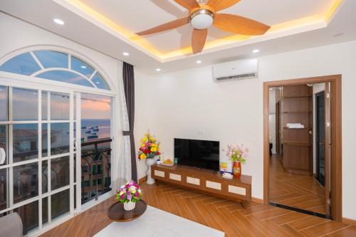 a living room with a ceiling fan and a television at Sun'House- Family 2BR Apt View Sea & Sunset Town Phu Quoc in Phu Quoc