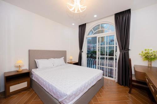 a bedroom with a bed and a large window at Sun'House- Family 2BR Apt View Sea & Sunset Town Phu Quoc in Phu Quoc