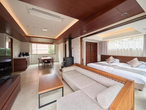 a living room with two beds and a couch at アドベンチャーズアイランド 小谷流沢ロッジ in Yachimata