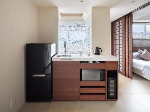 cocina con fregadero y nevera en una habitación en アドベンチャーズアイランド 小谷流沢ロッジ, en Yachimata