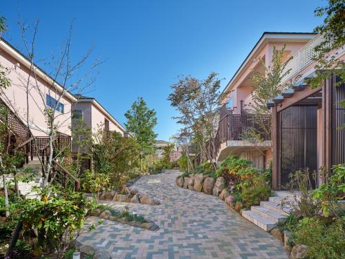 a cobblestone path between two houses at アドベンチャーズアイランド 小谷流沢ロッジ in Yachimata