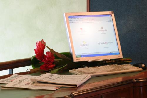 a computer monitor and keyboard on a desk with a flower at Air Hotel in Forlì