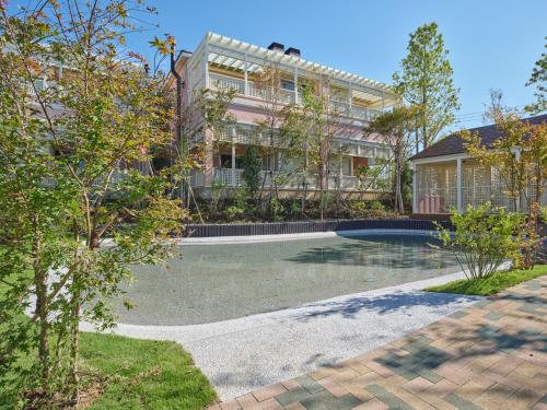 a house with a swimming pool in front of a building at アドベンチャーズアイランド 小谷流沢ロッジ in Yachimata