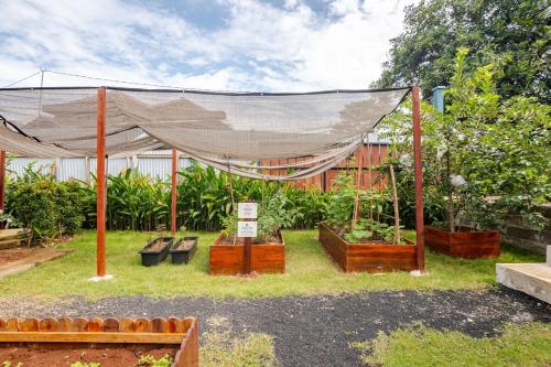 a garden with a canopy and benches and plants at Casa Candali, Farm Haven - Bogor Short Getaway - Respectful Guest Only in Bogor