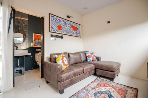 a living room with a brown couch and a table at Casa Candali, Farm Haven - Bogor Short Getaway - Respectful Guest Only in Bogor