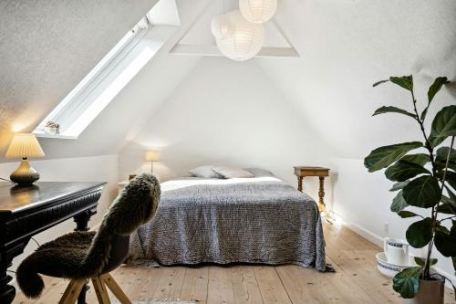 a bedroom with a bed and a piano at Timber-Framed With Bright And Idyllic Garden in Juelsminde