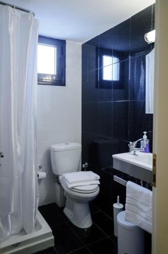- une salle de bains en noir et blanc pourvue de toilettes et d'un lavabo dans l'établissement Ancient Tiryns, à Nauplie