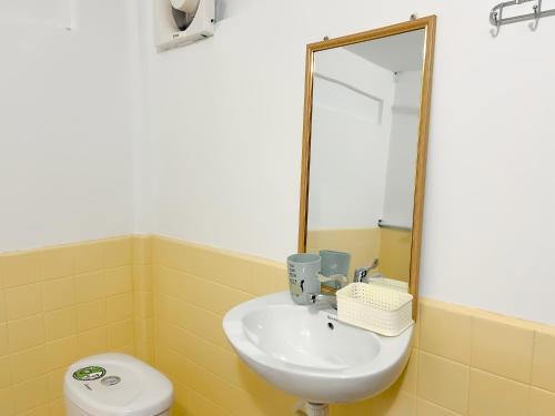 a bathroom with a sink and a mirror and a toilet at Lotus Blanc Homestay Village in Battambang