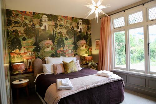 a bedroom with a large bed with a large mural at Casterton Cottage, paradise garden with spa in Christchurch