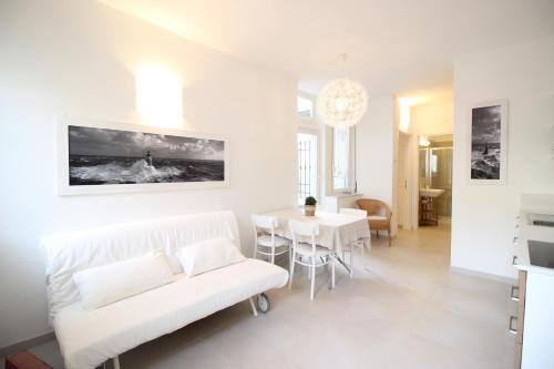 a white living room with a white couch and a table at Pochi Passi dal Mare in San Bartolomeo al Mare