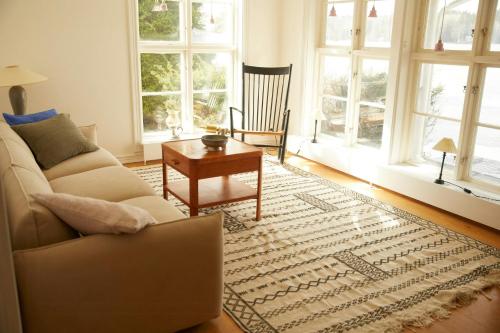 a living room with a couch and a table and windows at Lake View Holiday Home With Natural Charm in Storfors