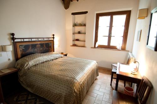 1 dormitorio con cama, ventana y mesa en Colle sul Lago, en Castiglione del Lago