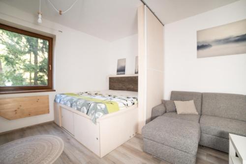 a small bedroom with a bed and a couch at Fatrapark 2 Apartments HRABOVO - Hlavná recepcia in Ružomberok