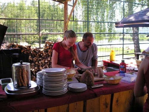 a man and a woman standing at a table with plates at Camp Telč - U Roštěnky in Telč
