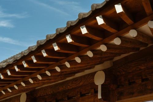 a wooden roof with white lights on top of a building at Myeongjigak in Namwon