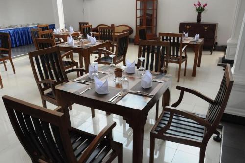 a dining room with wooden tables and chairs at Blue Spring Hotel Wadduwa in Wadduwa