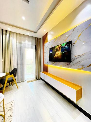 a living room with a tv on a wall at SN suites apartment in Kampala