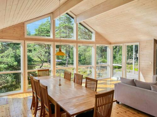 a dining room with a large wooden table and chairs at Family Cabin With Panoramic Windows By Oksrødkilen in Gressvik