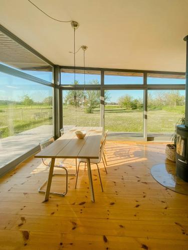 a dining room with a table and a large window at Natural Wooden House With Panoramic View in Ihlow
