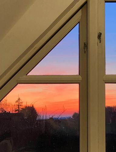 a window with a view of a sunset at Farmhouse With Bath And Field View in Kalundborg