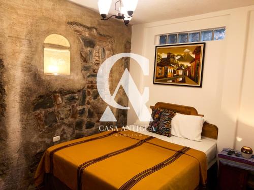 a bedroom with a bed and a stone wall at Casa Altavista in Antigua Guatemala