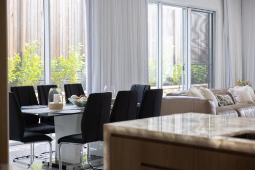 a living room with a table and chairs and a couch at Stylish 4-Bed Home with Pool Near Coolum Beach in Coolum Beach