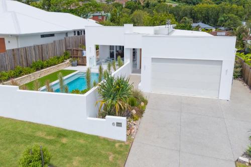 an aerial view of a white house with a swimming pool at Stylish 4-Bed Home with Pool Near Coolum Beach in Coolum Beach