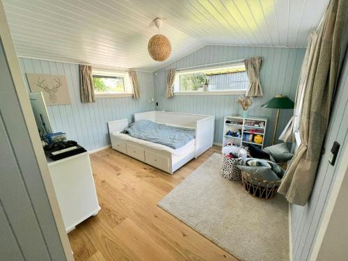 Un pequeño dormitorio con una cama y una silla. en Home For Family In Tisvilde, en Tisvildeleje