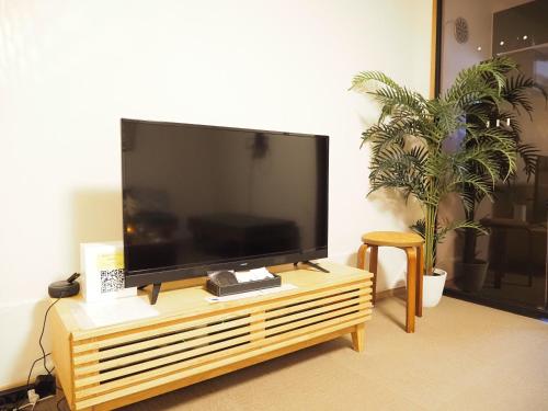 a large flat screen tv sitting on a wooden stand at T-home2 1F in Tokyo