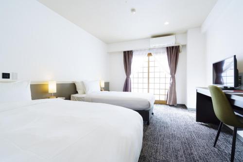 Postel nebo postele na pokoji v ubytování Hakuba Gateway Hotel