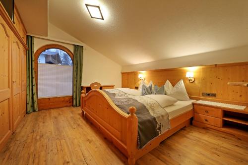 a bedroom with a bed and a large window at Landhaus & Apartment Taxach in Ried im Zillertal