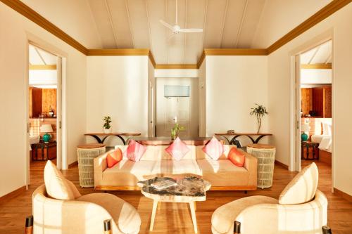 a living room with a couch and a table at Sun Siyam Iru Veli - 24 Hours Premium All-Inclusive with Free Transfers in Dhaalu Atoll