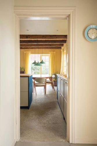 a kitchen and dining room with a table and a clock at Historic Fisherman's Gem With Twist In Klitmøller in Torsted