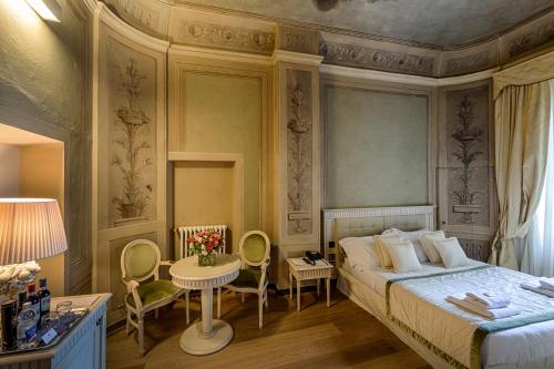 1 dormitorio con 1 cama, mesa y sillas en Palazzo Guicciardini, en Florencia