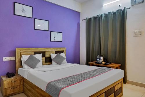 a bedroom with a large bed with purple walls at Super Townhouse Hinjewadi in Pune