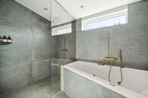 une salle de bain avec une baignoire et une fenêtre dans l'établissement Classic Seaside Hotel Feel In Ringkøbing Fjord, à Hemmet